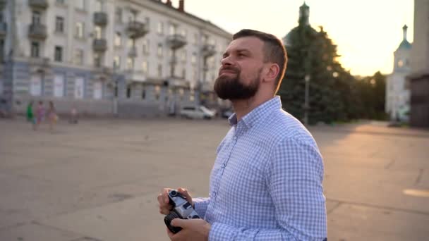 Man loopt rond de stad en het nemen van foto's van de bezienswaardigheden op een filmcamera — Stockvideo