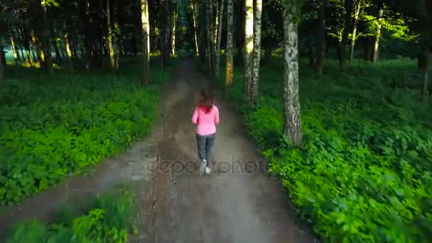 Femme court à travers la forêt 