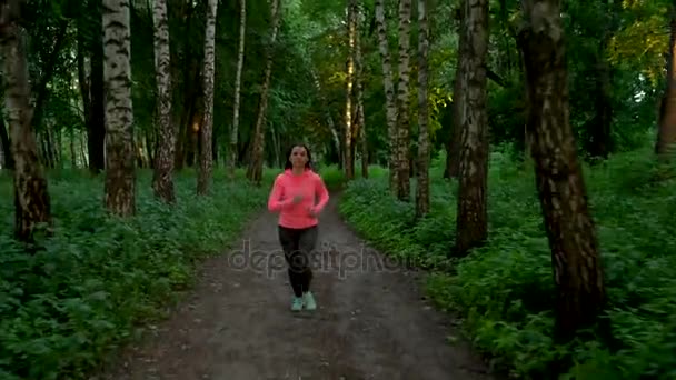 Femme court à travers la forêt 