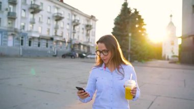 Smartphone üzerinde konuşmak ve caddeden aşağı yürüyüş suyu içme kadın yavaş hareket