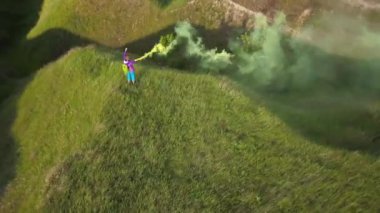 Kadın turist bir tepe ve duman bombası ile sallayarak en üstünde duruyor