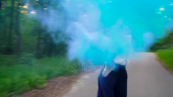 Женщина в красивой одежде бежит по лесу размахивая цветным дымом — стоковое видео