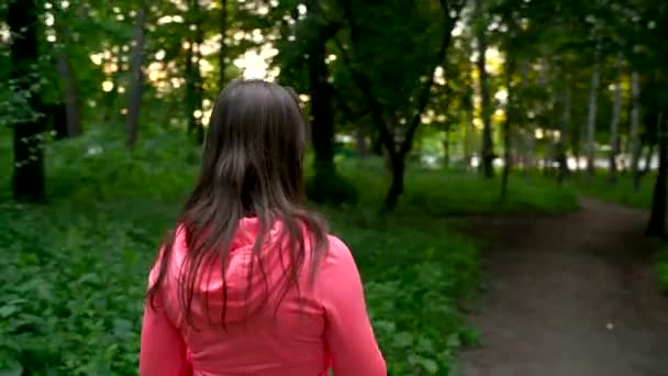 Kvinna dricka vatten och vilar medan joggning i skogen — Stockvideo