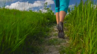 Kadın hiking bir sırt çantası ile engebeli arazi üzerinden sahiptir. Hiking