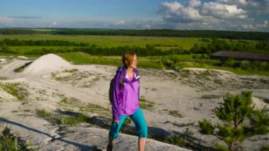 Kadın bir sırt çantası ile engebeli arazi üzerinde dolaşıyor. Hiking
