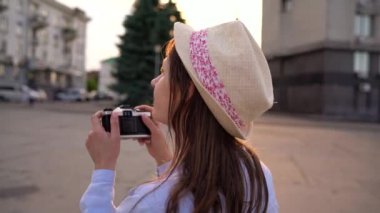 Kız şehir ve turistik fotoğraflarını alarak çevresinde bir film kamerası üzerinde yürüyor