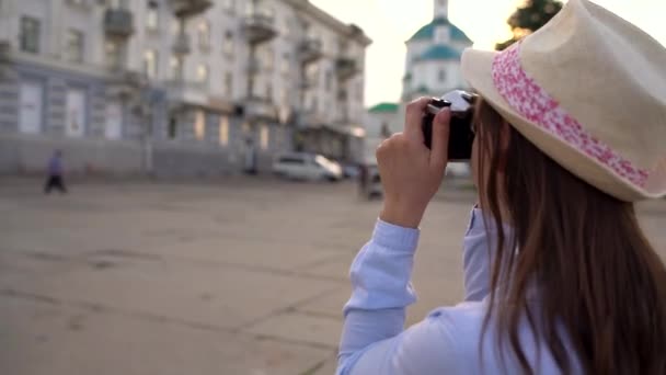 Menina está andando pela cidade e tirar fotos de vistas em uma câmera de filme — Vídeo de Stock