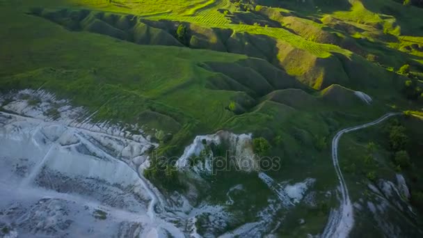Vol au-dessus d'une carrière de craie et paysage avec prairies, collines et arbres — Video