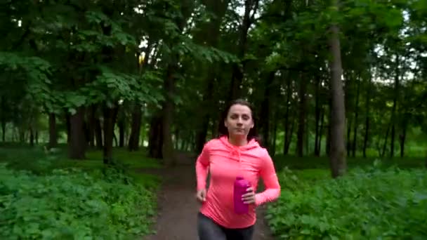 Женщина бежит через лес — стоковое видео