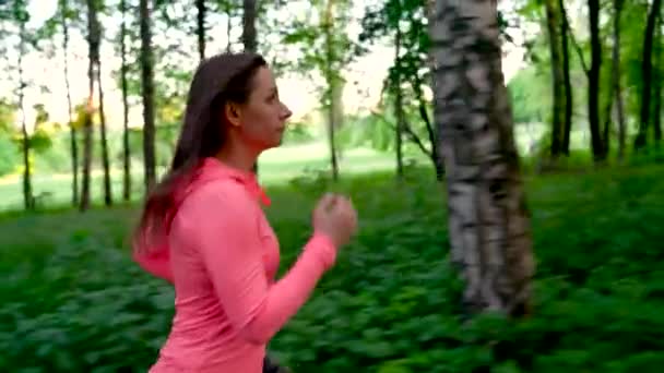 La mujer corre por el bosque, en cámara lenta — Vídeos de Stock
