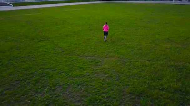 Vrouw loopt door het stadion bij zonsondergang, uitzicht vanaf de top — Stockvideo