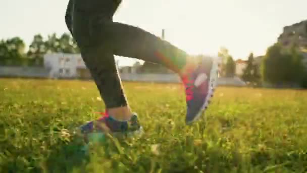 La mujer corre por el estadio al atardecer — Vídeos de Stock