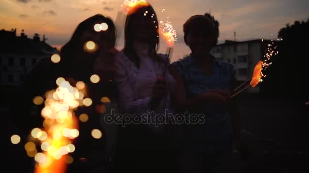 Três amigas se divertindo e brincando com velas de fogo de artifício — Vídeo de Stock