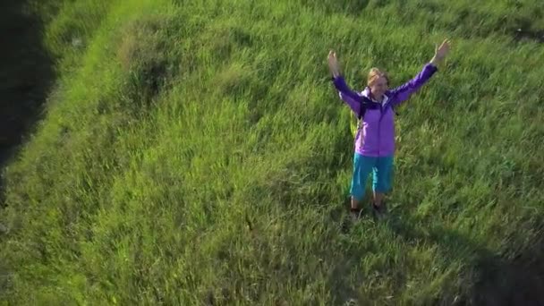 Vrouw houdt van rondreizen met een rugzak over heuvelachtig terrein. Wandelen. Uitzicht vanaf de hoogte — Stockvideo