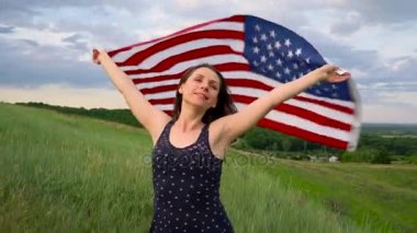 Kadın bir ABD bayrağı sallayarak bir tepe üstünde tepe-in - Bağımsızlık günü ABD kavramı duruyor