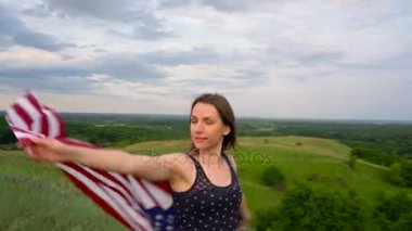 Kadın bir ABD bayrağı sallayarak bir tepe üstünde tepe-in - Bağımsızlık günü ABD kavramı duruyor