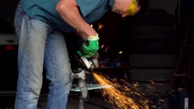 Erkek orta yaşlı işçi köşeli taşlama tezgahı ile metal kesme