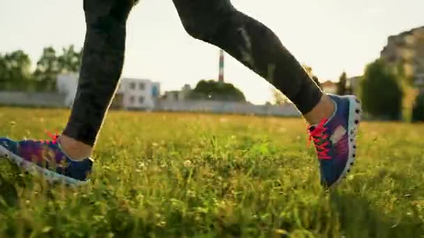 La mujer corre por el estadio al atardecer. Movimiento lento — Vídeos de Stock