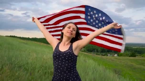 Nő integet egy Egyesült Államok zászlót áll, egy domb tetején - a fogalom az Usa a függetlenség napja — Stock videók