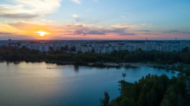 Ağaçlar ve şehrin şafak - hava phot göl üzerinde uçan