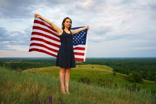 Dumna kobieta z USA flaga stoi na szczycie wzgórza — Zdjęcie stockowe