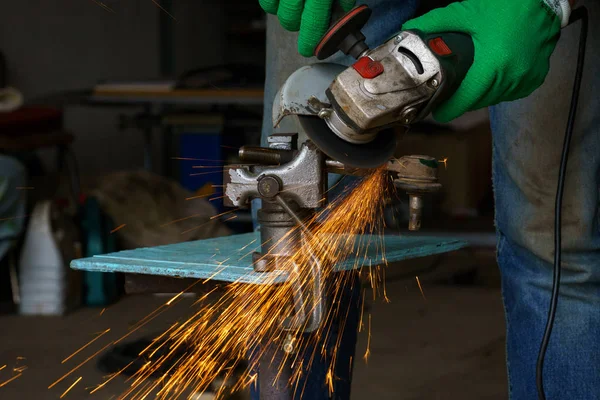 Trabalhador com máquina de moagem angular está cortando o metal — Fotografia de Stock