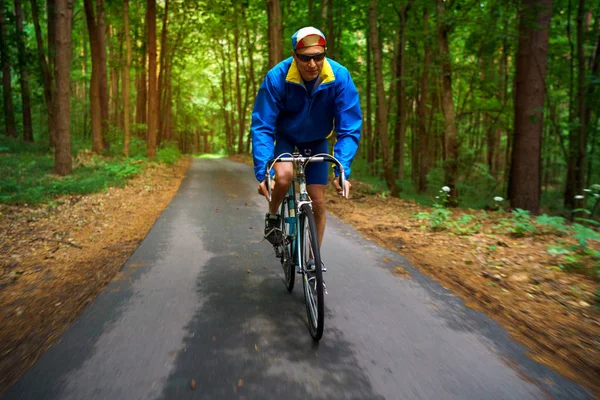 フォレスト ロード沿いの道のバイクに乗っている中年の男 — ストック写真