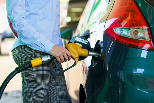 Mulher enche gasolina no carro em um posto de gasolina — Fotografia de Stock