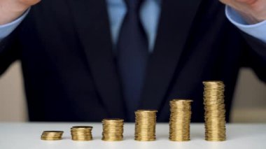 Adam yığın altın sikke sütun artan içine ve onları mahvediyor