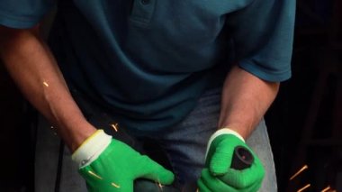 Erkek orta yaşlı işçi köşeli taşlama tezgahı ile metal kesme
