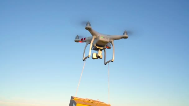 Drone entrega paquete en el fondo del cielo. Movimiento lento — Vídeo de stock