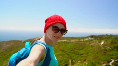 Beni - mutlu genç kadın kırmızı bir şapka ve çocuklar el çekerek onun arkasından bir sırt çantası ile takip edin. El el okyanus sahile yürüme