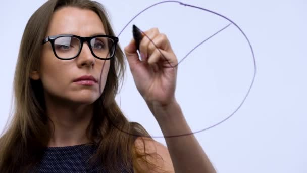 Woman draws various growth charts, calculating prospects for success in a modern glass office — Stock Video