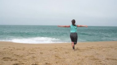 Plaj boyunca çalıştıran atletik kadın. Ağır çekim