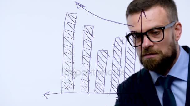Человек рисует различные схемы роста, рассчитывая перспективы успеха в современном стеклянном офисе — стоковое видео