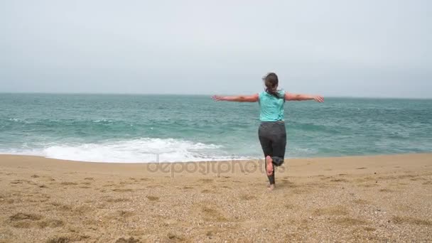 Mujer atlética corriendo por la playa. Movimiento lento — Vídeo de stock