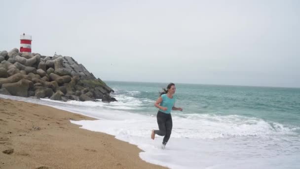 Donna atletica che corre lungo la spiaggia — Video Stock