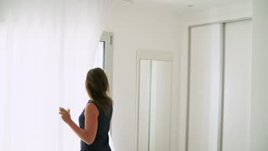 Onun yatak odası perdeleri açmayı ve ağır çekimde portakal suyu içme kadın