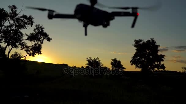 Силуэт маленького квадрокоптера, летящего по небу — стоковое видео