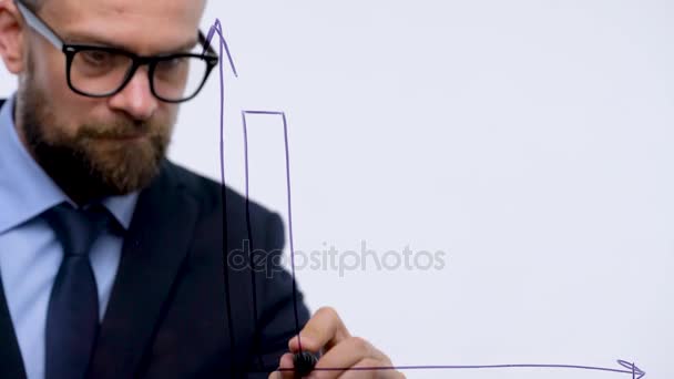 L'homme dessine différents graphiques de croissance, calculant les perspectives de succès dans un bureau en verre moderne — Video