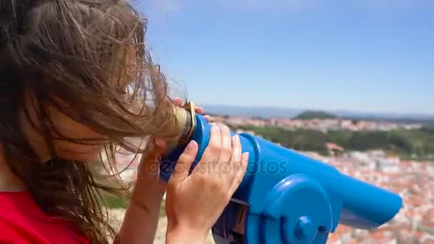 Turista femenina usando binoculares pagados con monedas en alta colina y mirando el paisaje urbano de Nazaret, Portugal, cámara lenta — Vídeos de Stock