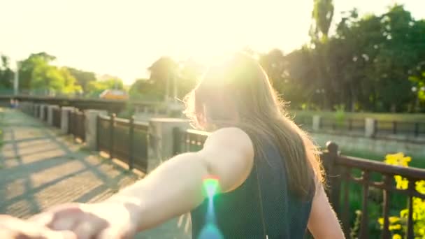 Siga-me - jovem mulher feliz puxando homens mão na mão andando em um dia ensolarado brilhante — Vídeo de Stock