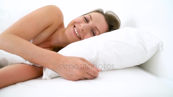 Linda chica durmiendo en la cama despertando estirándose y sonriendo — Vídeos de Stock