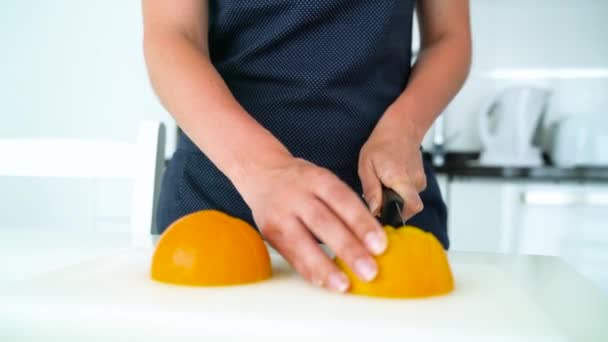 Woman cutting orange in a modern kitchen — Stock Video