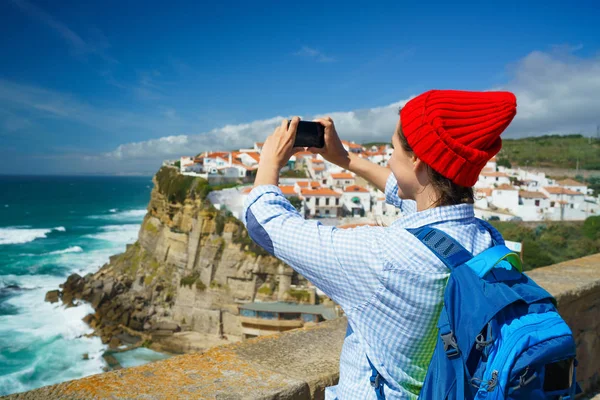 Mulher com uma mochila faz uma foto no smartphone de uma beleza — Fotografia de Stock