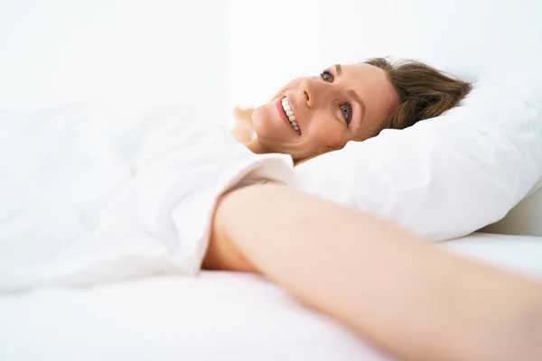 Menina bonito dormir na cama acordar alongamento e sorrindo — Fotografia de Stock