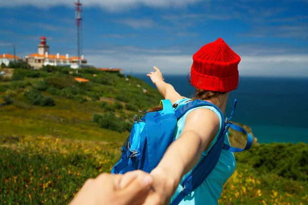 Följ mig - glad ung kvinna i en röd hatt och med en ryggsäck b — Stockfoto