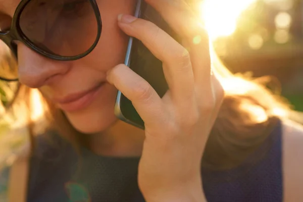 Mujer con gafas de sol hablando en el smartphone mientras camina — Foto de Stock