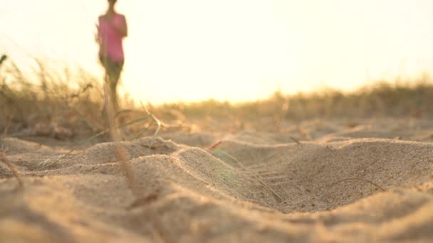 Buty do biegania - kobieta wiązanie sznurówki do butów na piaszczystej plaży o zachodzie słońca — Wideo stockowe