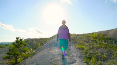 8 in 1 video. Kadın bir sırt çantası ile engebeli arazi üzerinde dolaşıyor. Hiking